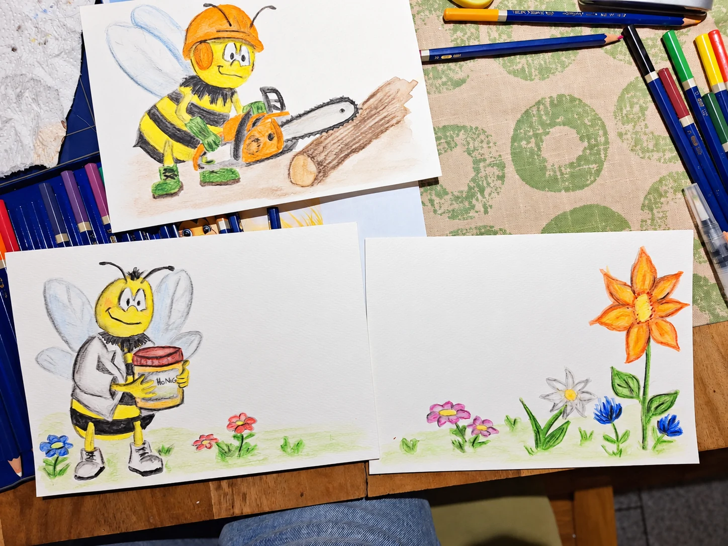 Drei frühe Bienenzeichnungen mit Kettensäge, Honigglas und Blumen auf Kristins Zeichentisch